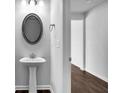 Bathroom featuring a pedestal sink, oval mirror and a view of the hallway and doorway at 3270 Forest Green Dr, Douglasville, GA 30135
