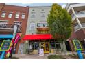 Building exterior featuring a green facade, red awning, and street-level businesses at 320 Town Center Ave # U206B, Suwanee, GA 30024