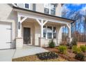 Front porch with white columns and dark brown front door at 1475 Auburn Glen Rd, Dacula, GA 30019