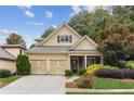 Beautiful two-story home with a three-car garage and lush landscaping at 8010 Majors Mill Dr, Cumming, GA 30041