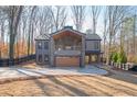 Modern farmhouse with metal roof, large garage, and covered patio at 600 Jones Rd, Roswell, GA 30075