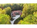 Aerial view of a luxury home featuring a red roof, circular driveway and nestled in lush, green landscaping at 1416 Walcutts Nw Way, Marietta, GA 30064