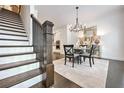 Staircase leading to a dining area, showcasing dark wood floors, and a stylish chandelier at 2341 Brissett Ln, Brookhaven, GA 30319