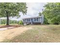 Two-story house with mature trees, landscaping, and driveway at 3950 Yancey Rd, Douglasville, GA 30135