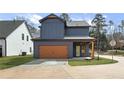 Exterior view showcasing a two-car garage and modern design elements with a well-maintained lawn at 42 Puckett Se Rd, Emerson, GA 30137