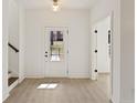 Bright foyer featuring wood-look floors, a staircase, and a white door, creating a welcoming entrance at 42 Puckett Se Rd, Emerson, GA 30137