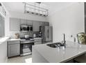 The modern kitchen is accented with stainless steel appliances, gray cabinets, and a quartz countertop at 2479 Peachtree Ne Rd # 105, Atlanta, GA 30305