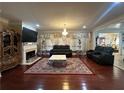 Elegant living room featuring hardwood floors, fireplace, chandelier and stylish furniture at 1621 Telfair Chase Way, Lawrenceville, GA 30043