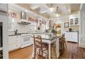 A well-lit kitchen features white cabinets, stainless steel appliances, a granite countertop island, and hardwood floors at 1045 N Main Nw St, Conyers, GA 30012