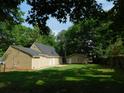 Expansive backyard with green lawn, patio area, and detached garage, perfect for outdoor living at 99 Libby Ln, Jonesboro, GA 30238
