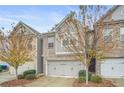 Attractive townhome featuring brick and siding, attached two-car garage, and appealing landscaping at 4429 Newfangle Rd, Stone Mountain, GA 30083