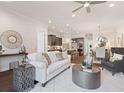 Open-concept living room with neutral tones and views of kitchen and dining areas at 308 Thistle Ct, Woodstock, GA 30189