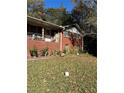 Side view of brick home featuring a cozy covered porch and landscaped yard at 5655 Campbellton Sw Rd, Atlanta, GA 30331