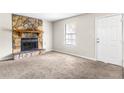 Inviting living room with a stone fireplace, neutral walls, new carpeting, and a bright window at 1185 Oak Villas Nw Ct, Conyers, GA 30012