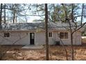 Rear view of a newly renovated house with a patio and wooded backdrop at 650 Fairforest Ct, Stone Mountain, GA 30088