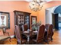 Well-appointed dining room with dark wood furniture, cabinet, and ornate decor accents for a luxurious feel at 86 Waterford Path, Hiram, GA 30141