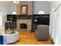 Cozy living room featuring a brick fireplace, built-in shelving, and hardwood floors at 86 Waterford Path, Hiram, GA 30141