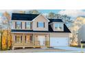 Two-story house with tan siding, dark roof, and a front porch at 6478 Beaver Creek Trl, Atlanta, GA 30349