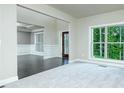 Bright and airy living room with large windows, white wainscoting, and dark hardwood floors at 5380 Deer Run Dr, Conyers, GA 30094
