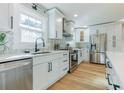 Modern kitchen with white cabinets, stainless steel appliances, and light hardwood floors at 2878 London Ne Ct, Marietta, GA 30062