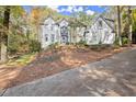 Two-story house with white brick exterior, landscaping, and a long driveway at 2680 Spalding Dr, Sandy Springs, GA 30350