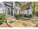 Charming front entrance with brick stairs and walkway, mature landscaping, and decorative lighting at 2680 Spalding Dr, Sandy Springs, GA 30350