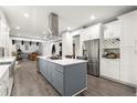 Modern kitchen with stainless steel appliances, a large island with a cooktop, and white cabinetry at 2680 Spalding Dr, Sandy Springs, GA 30350