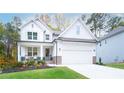 Two story white farmhouse with stone accents and landscaped yard at 51 Riverbirch Way, Dallas, GA 30157