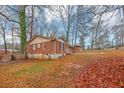 A red brick home sits on a lot with plenty of trees in the background at 1350 Ruth, Decatur, GA 30035