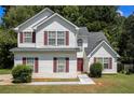Inviting two-story home with red shutters, white siding, and a manicured front yard at 4103 Kingship Dr, Ellenwood, GA 30294