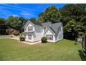 Well-maintained two-story home featuring white siding, manicured lawn, and mature trees at 4103 Kingship Dr, Ellenwood, GA 30294