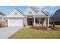 Gray brick home with white accents, 2-car garage, and landscaping at 2760 Marie Way, Cumming, GA 30028