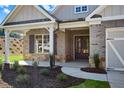 Covered front porch with stone accents and double front doors at 2735 Marie Way, Cumming, GA 30028