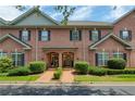 Charming brick townhome with manicured landscaping, symmetrical design, and convenient parking at 1950 Buford Dam Rd # 105, Cumming, GA 30041