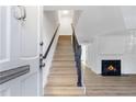 Inviting foyer with light wood staircase, neutral walls, and a glimpse of a cozy fireplace at 10 Chaumont Nw Sq, Atlanta, GA 30327