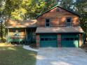 Two-story house with wood siding, green trim, and a two-car garage at 100 Lakeside Dr, Covington, GA 30016