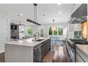 Open-concept kitchen featuring stainless steel appliances, large island, and view into the living and dining areas at 2941 Lookout Ne Pl, Atlanta, GA 30305