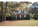 Charming red brick home with manicured landscaping and a basketball hoop in the driveway at 210 Huiet Dr, Mcdonough, GA 30252