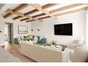 Comfortable living room area with wood beams, modern lighting, and large screen tv at 10939 Serenbe Ln, Chattahoochee Hills, GA 30268