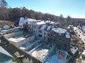 New homes under construction on a hillside with wooded backdrop at 10935 Serenbe Ln, Chattahoochee Hills, GA 30268