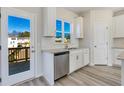 Kitchen features white cabinets, granite countertops, and a door leading to a deck at 214 Wilder Ridge Way, Lawrenceville, GA 30044