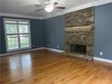 Spacious living room with hardwood floors, a stone fireplace, and large windows at 815 Sylvan Dr, Marietta, GA 30066
