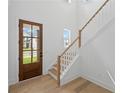 Bright foyer featuring a wood door with glass panels and hardwood stairs with white risers and a wooden handrail at 729 Keystone Dr, Woodstock, GA 30188