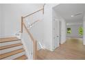 Elegant staircase with wooden treads and white risers, complemented by a light wood handrail and white walls at 729 Keystone Dr, Woodstock, GA 30188