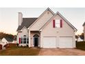 Inviting two-story home featuring a two-car garage, arch window, and manicured front yard at 137 St Ann Cir, Dallas, GA 30157