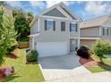 Charming two-story home features a two-car garage, neutral siding and dark shutters at 363 Lobdale Falls Dr, Lawrenceville, GA 30045