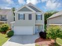 Charming two-story home features a two-car garage, neutral siding and dark shutters at 363 Lobdale Falls Dr, Lawrenceville, GA 30045