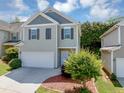 Charming two-story home features a two-car garage, neutral siding and dark shutters at 363 Lobdale Falls Dr, Lawrenceville, GA 30045