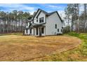 Charming two-story home with black trim and a covered porch, surrounded by a green lawn and trees at 3745 Pilgrim Mill Rd, Cumming, GA 30041