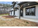 Close-up of a covered front porch featuring wood beams, stone pathway, and a gray trim at 3745 Pilgrim Mill Rd, Cumming, GA 30041